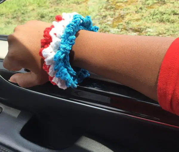 The Patriotic Bracelet is made with worsted weight cotton yarn in just 30 minutes! Learn how to make the chain loop stitch with this crochet accessory.