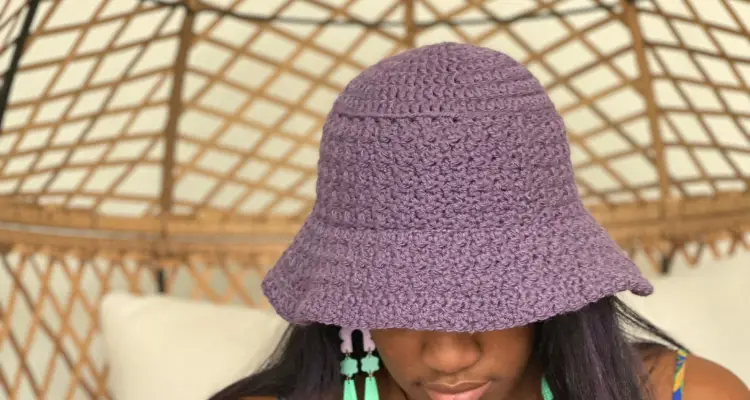 An image of a violet crochet bucket hat with subtle texture