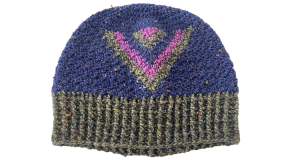 An image of a crochet hat made in a tweed yarn in navy blue, green and purple. It was has an inverted triangle shape with all three colors at the front. The majority of the hat is navy blue and the ribbing is green.