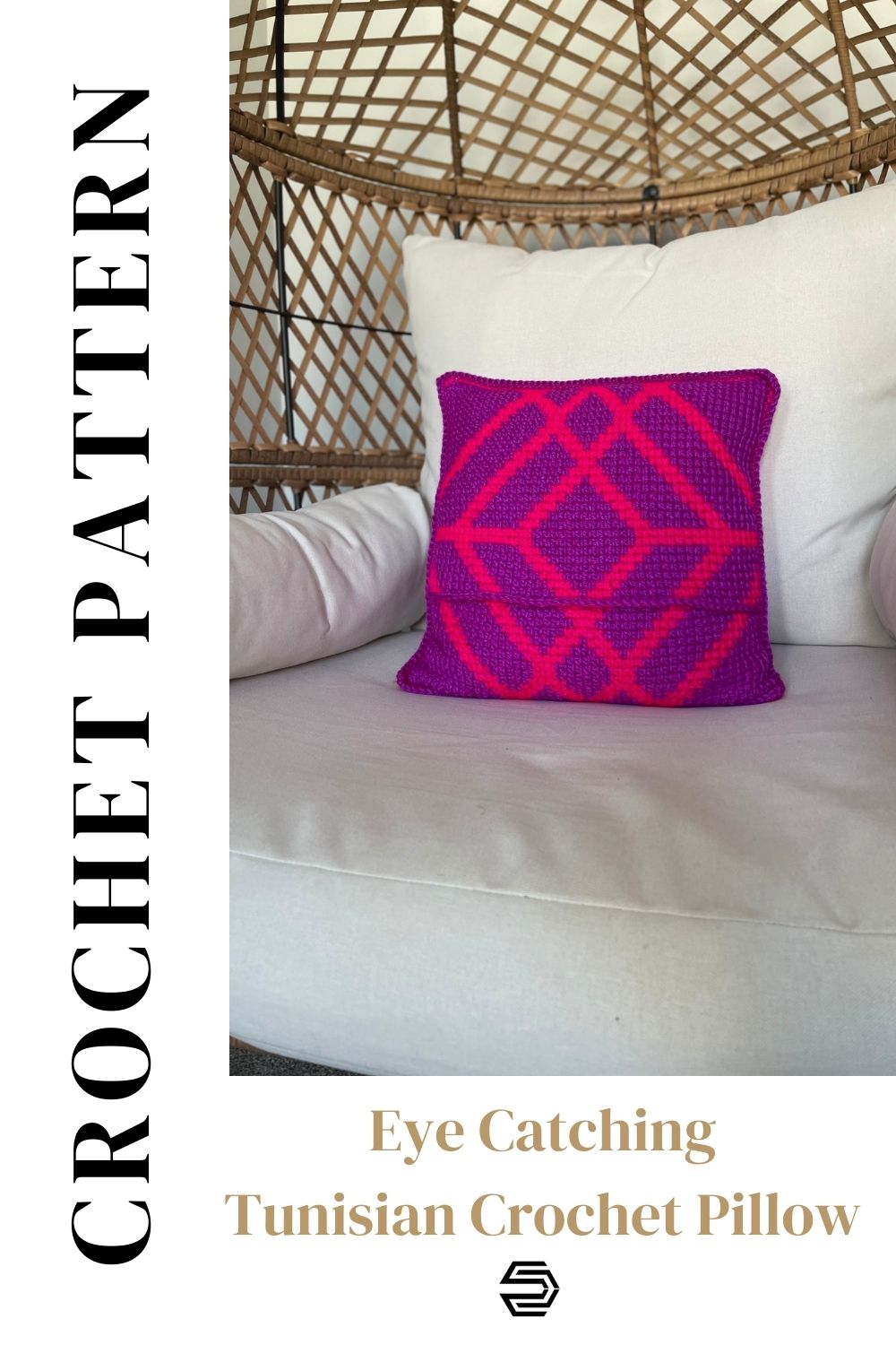 An image of a square tunisian crochet pillow laying in a wicker chair. The tunisian crochet pillow features large overlapping bright pink diamond shapes on a purple background. It is made of two pieces for inserting the pillow form.