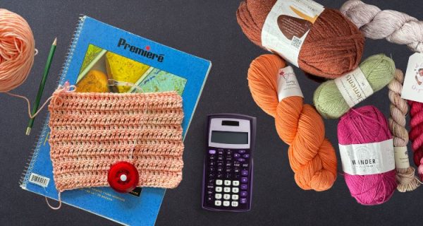Flat lay of various colorful yarn skeins, a crochet swatch with a red measuring tape, a pencil, notebooks, and a purple calculator on a dark background. The image suggests tools needed to calculate yarn amounts for crochet or knitting projects.
